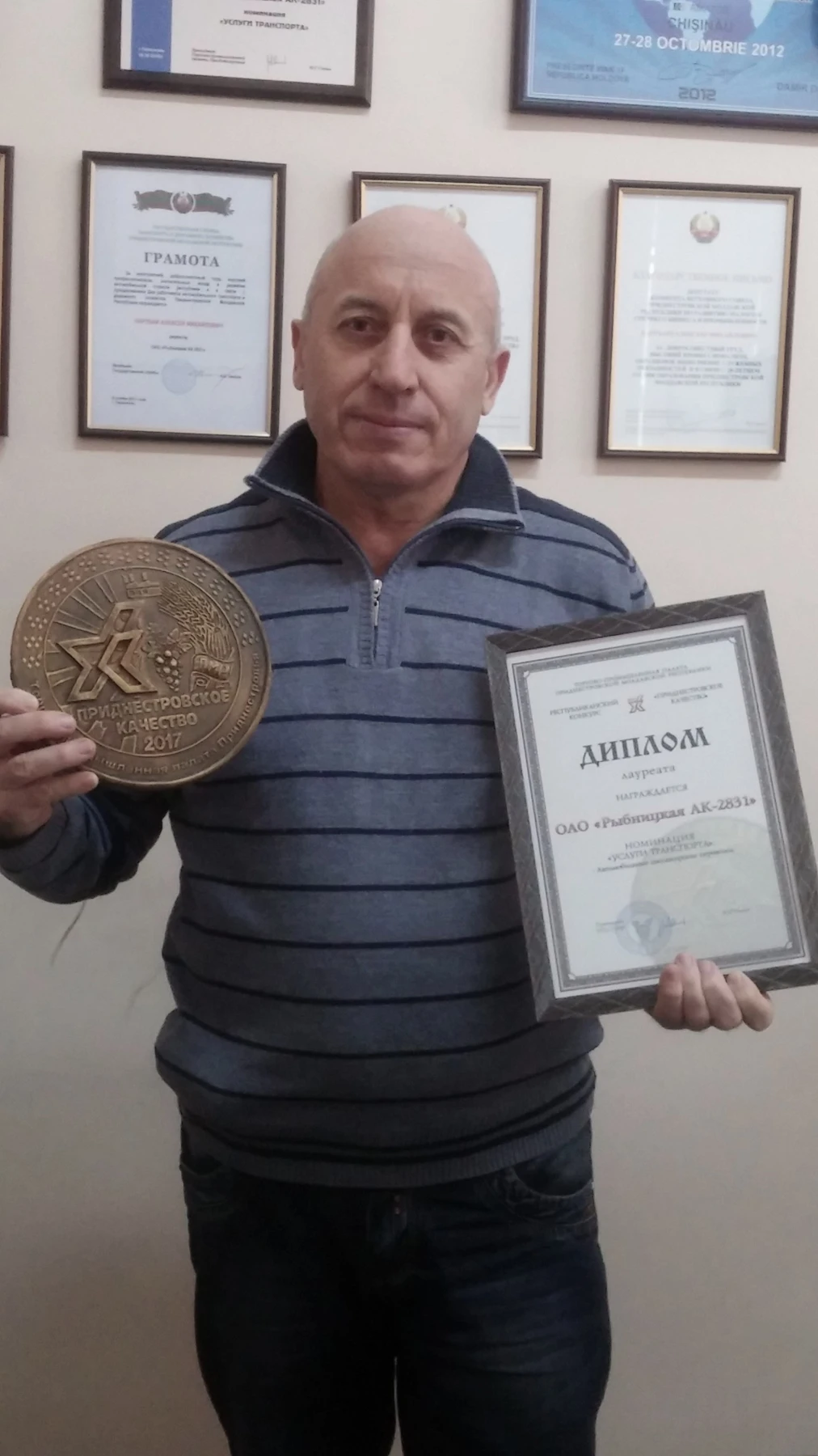 Сотрудник предприятия с медалью и дипломом
